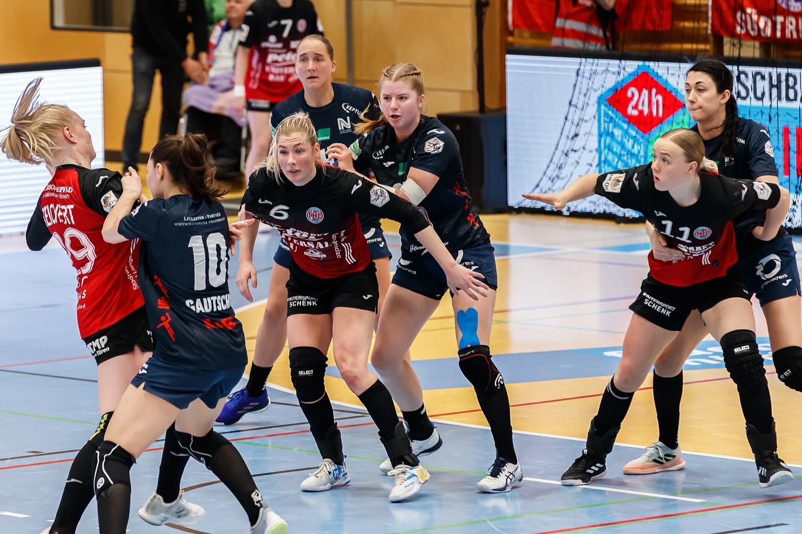 Geschlossene Abwehrreihe im Handball: mehrere Verteidigerinnen stellen sich der Angreiferin mit Ball in den Weg