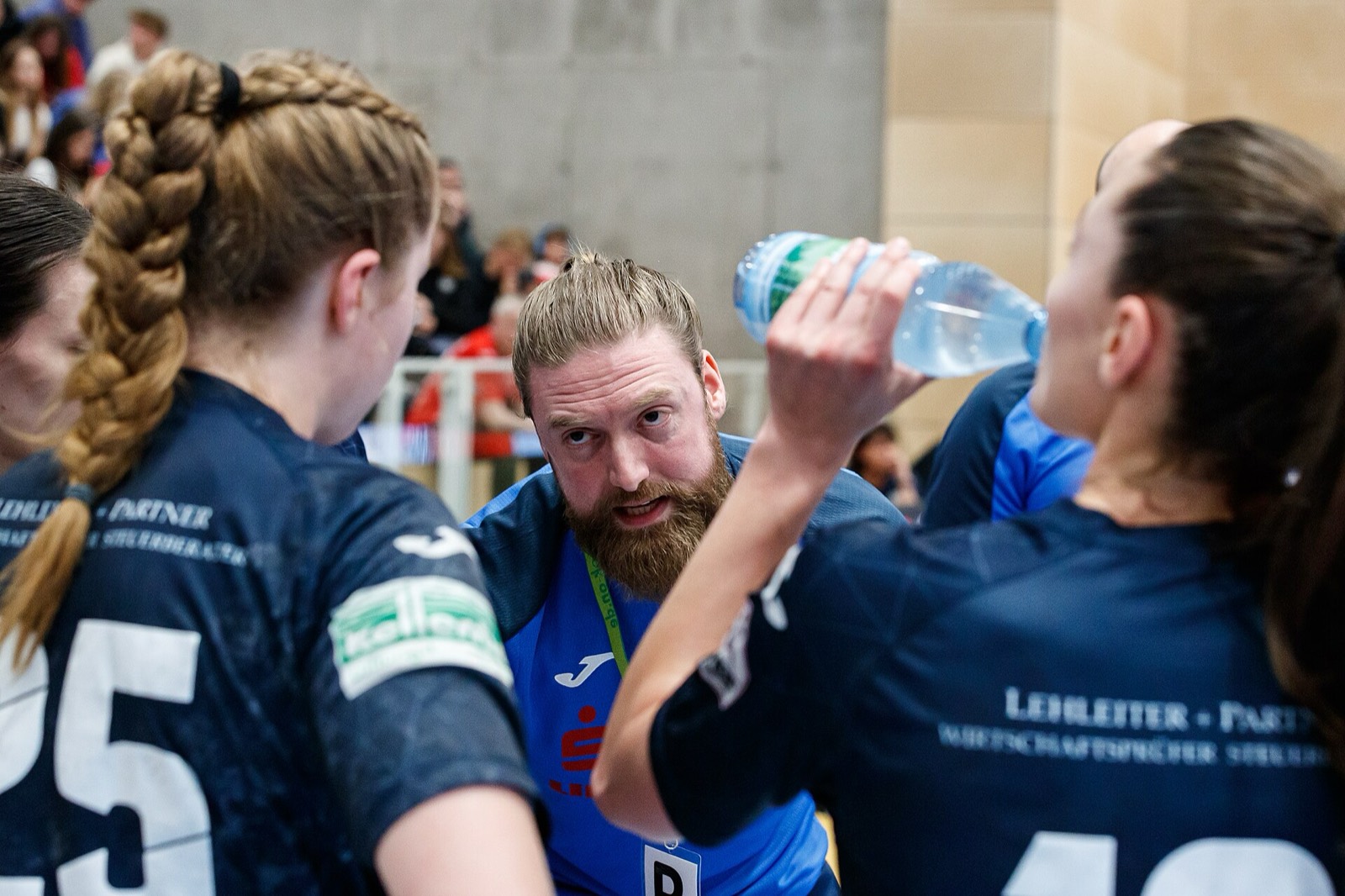 Handballtrainer spricht in der Auszeit eindringlich mit seinen Spielerinnen